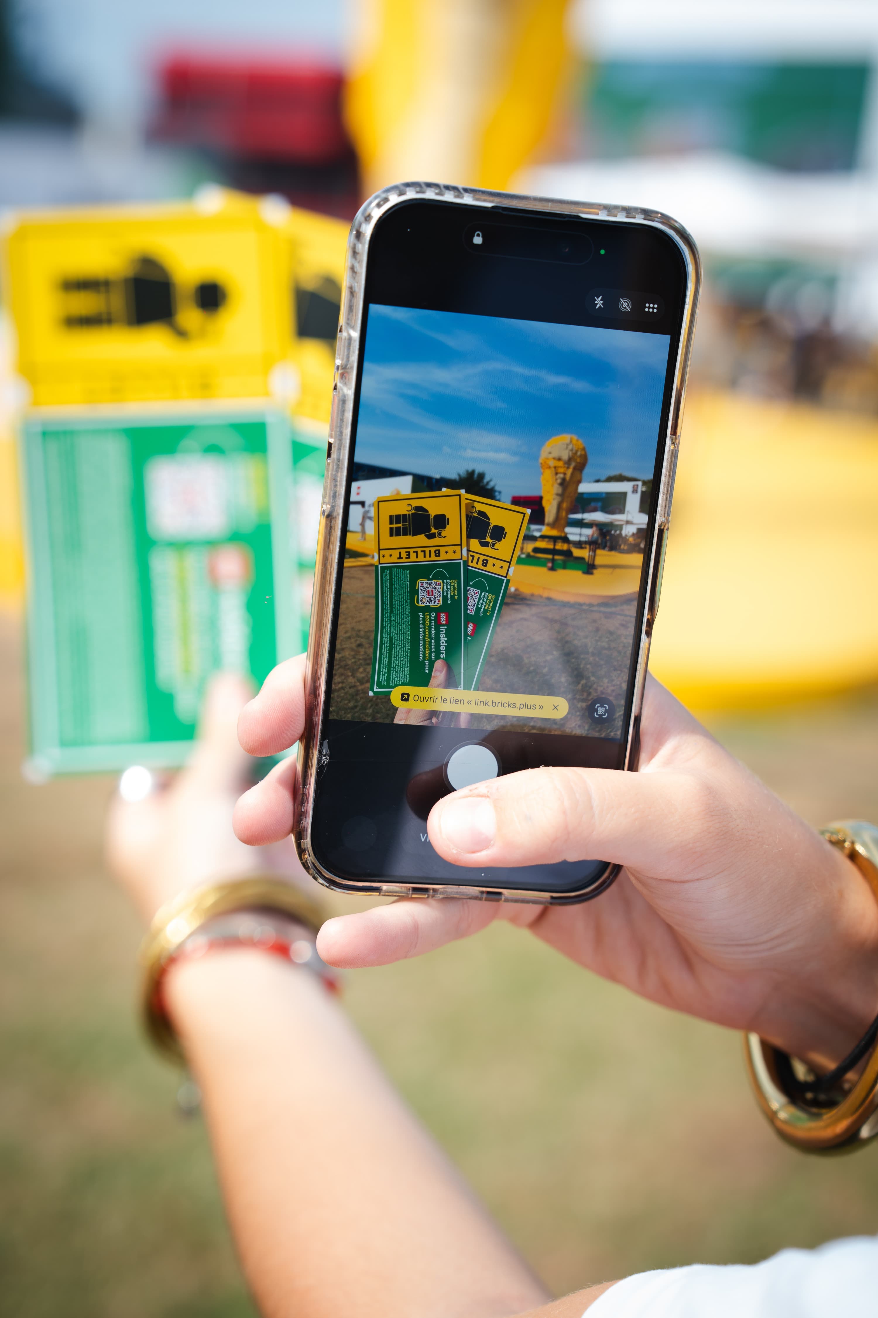 Un visiteur photographie le trophée LEGO avec son téléphone