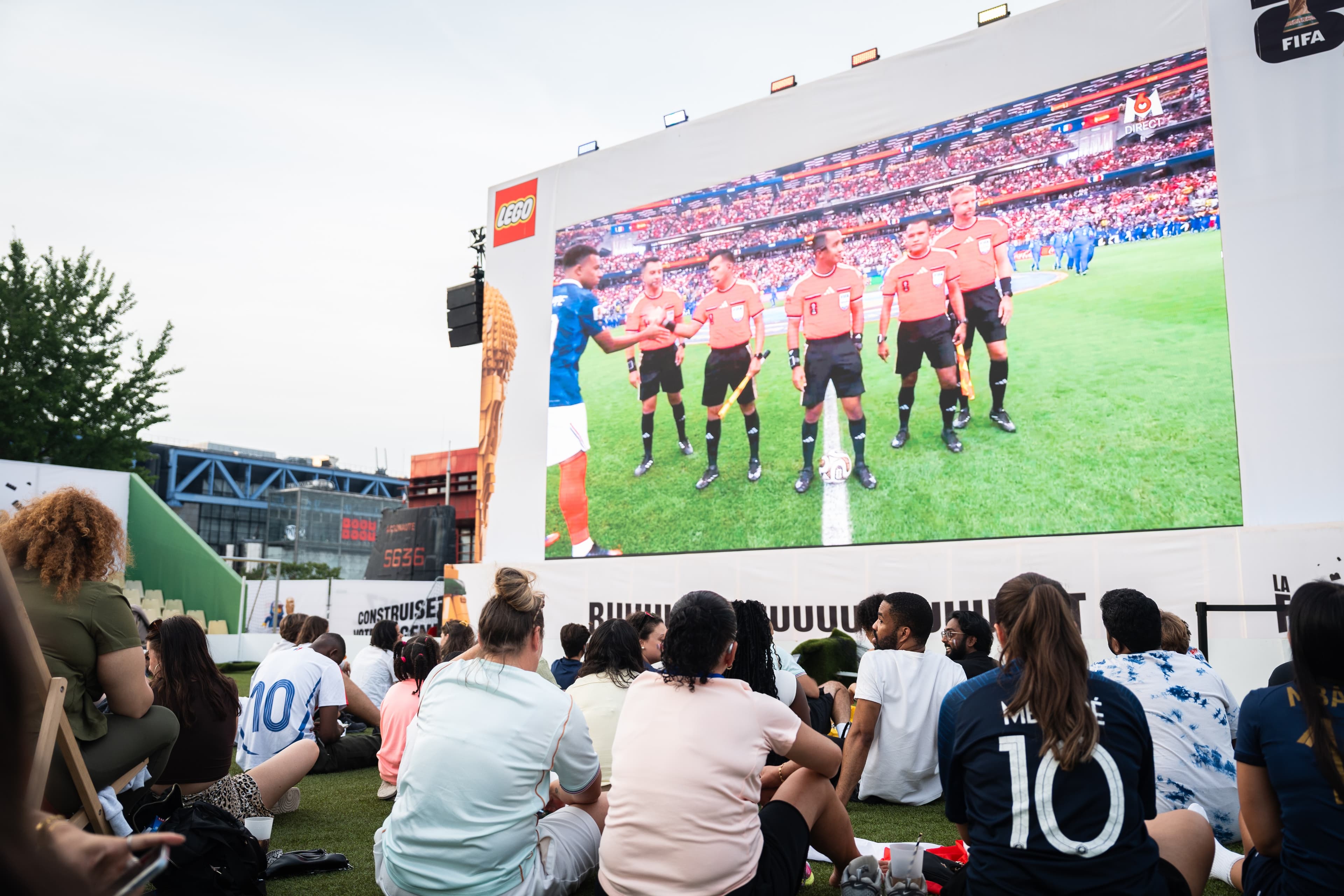 Public devant l'écran géant de la Fan Zone LEGO pendant un match