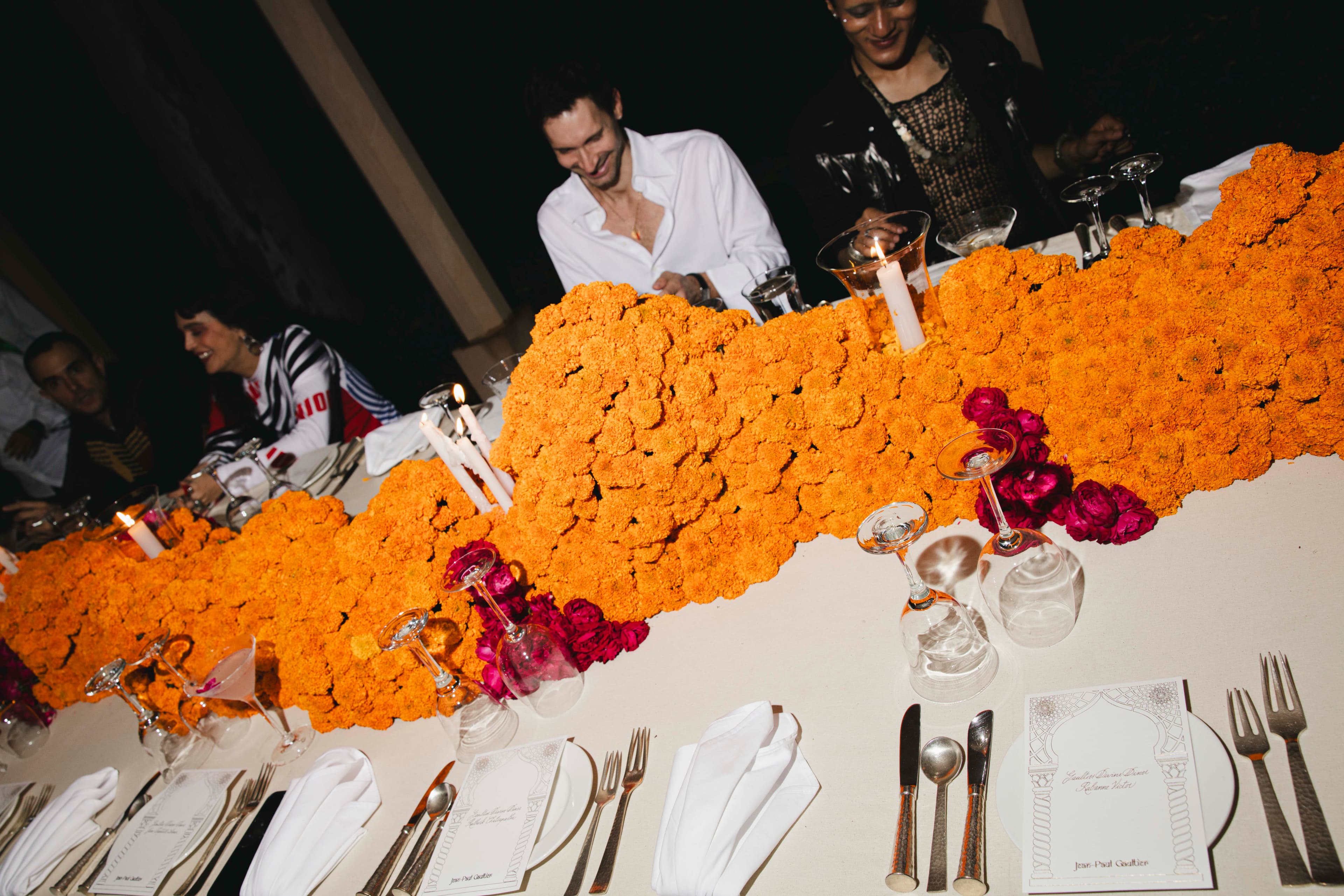 Longue table de dîner décorée de fleurs de souci orange pendant le voyage Jean Paul Gaultier au Rajasthan