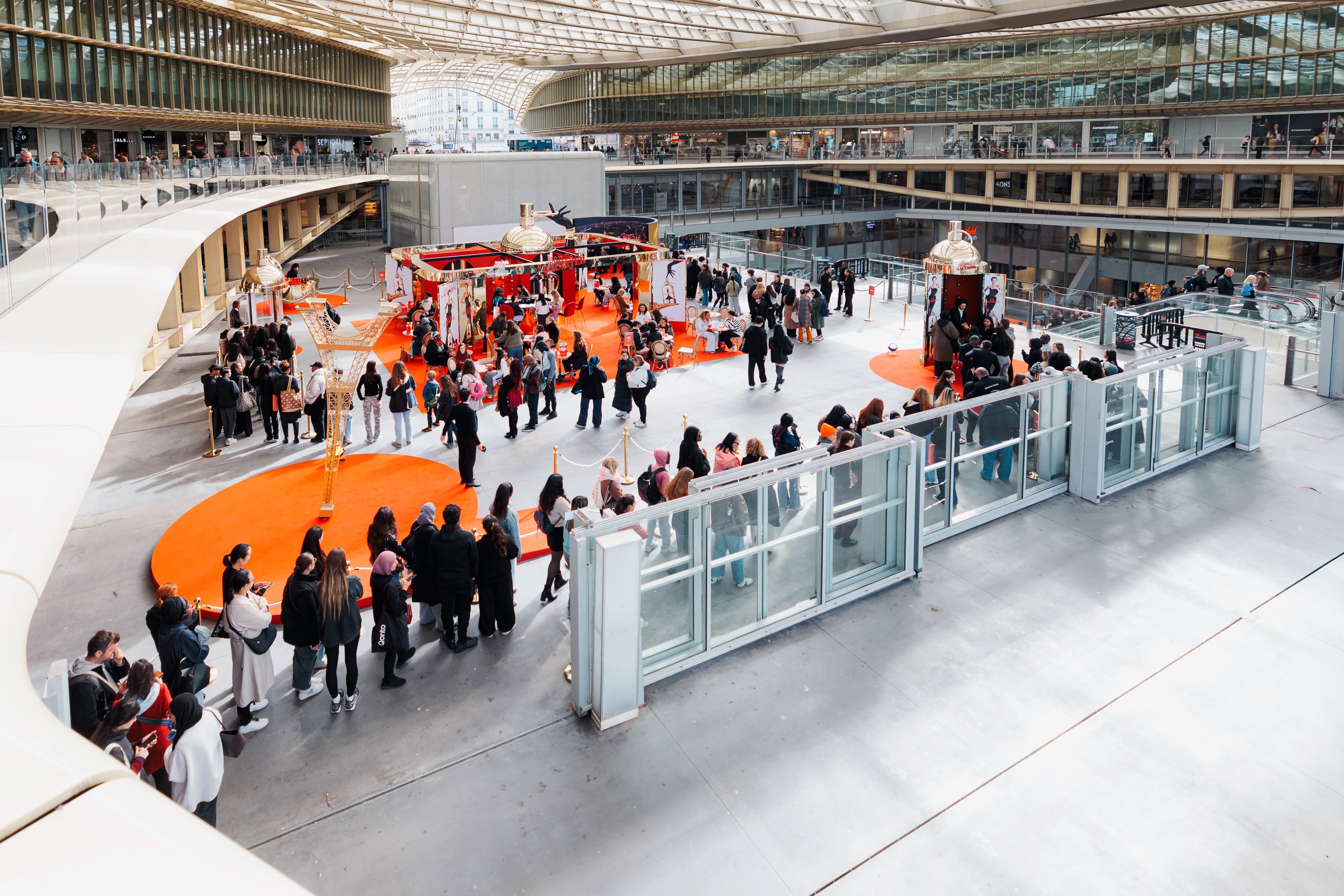 Vue plongeante sur le pop-up La Favorite de Jean Paul Gaultier et la file des visiteurs sous la Canopée des Halles