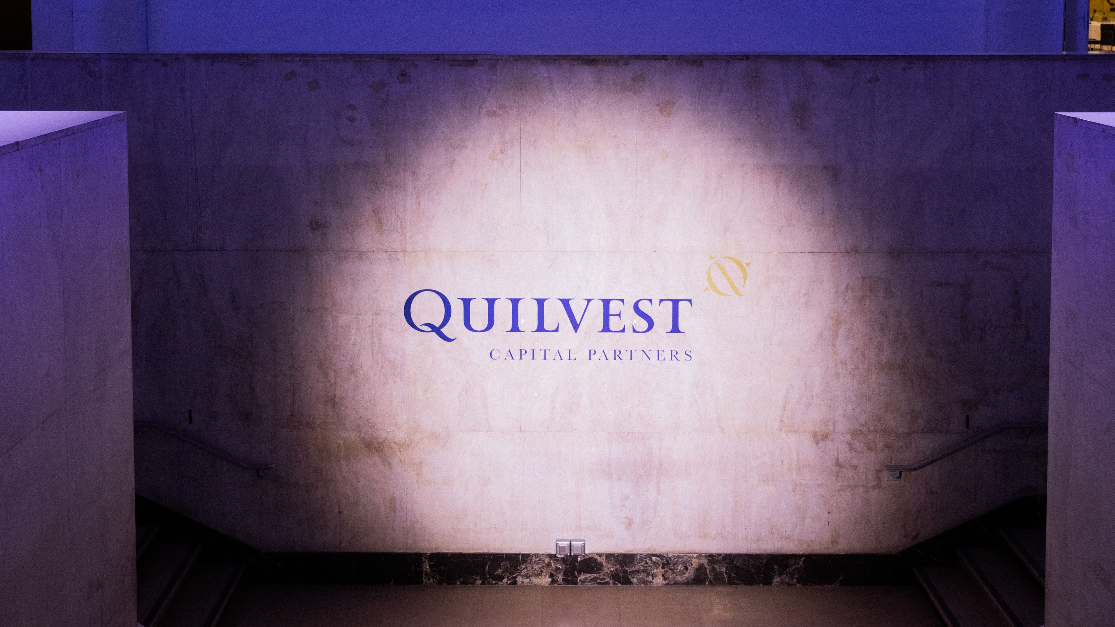 Logo Quilvest Capital Partners projeté sur un mur du Palais de Tokyo lors de l'Investor Day 2026
