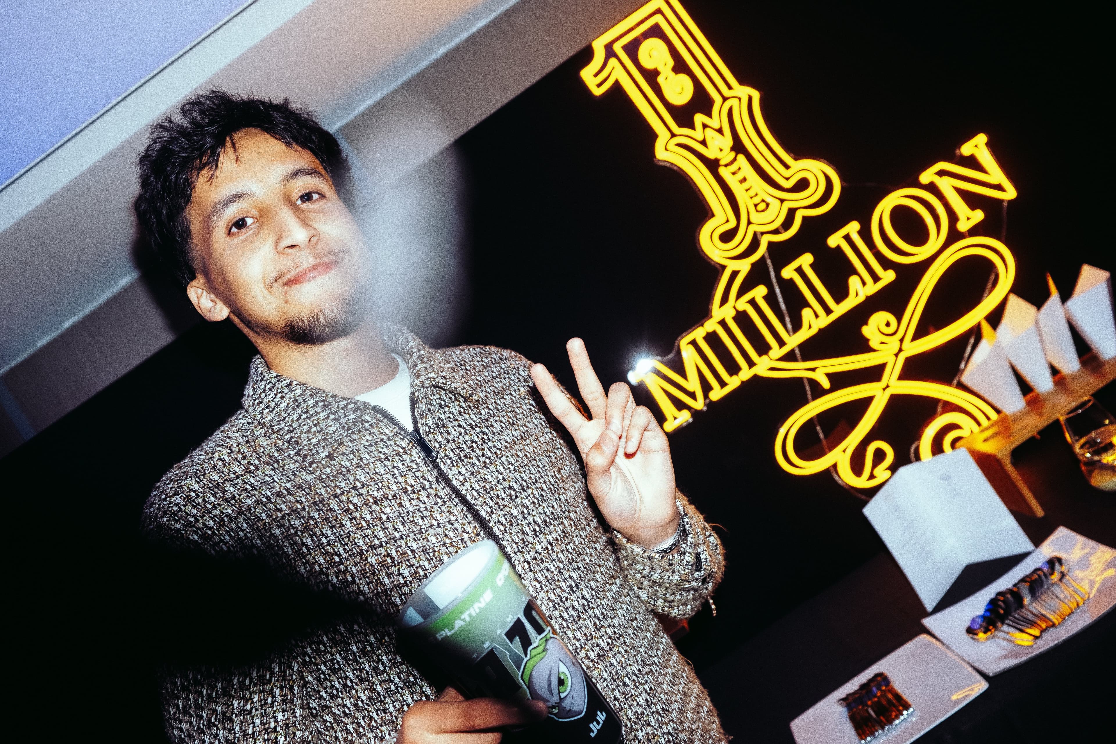 Invité posant devant le néon One Million