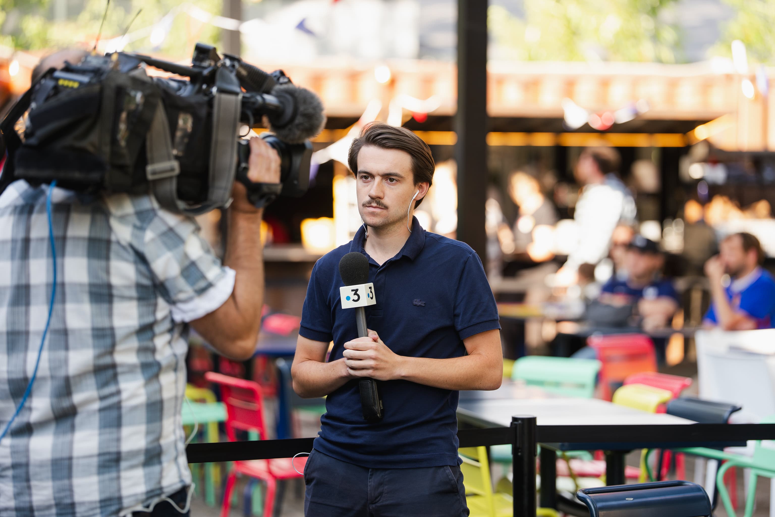Journaliste de France 3 en reportage devant le dispositif Ricard lors d'une étape de la tournée