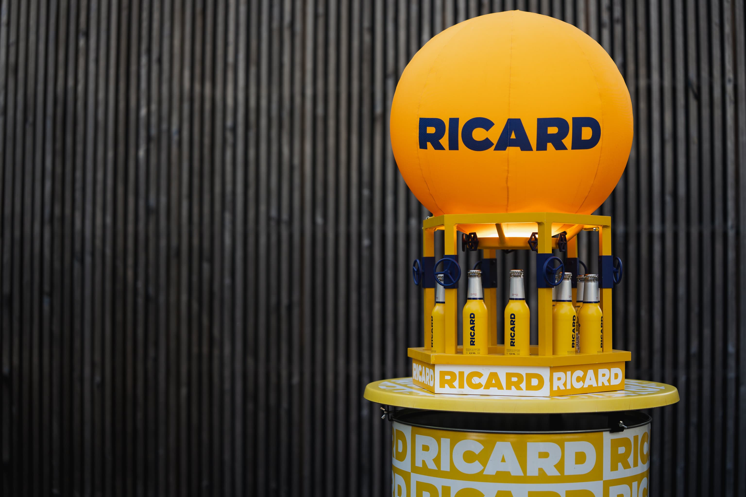 Totem Ricard avec ballon gonflable et présentoir de bouteilles installé sur une étape de la tournée
