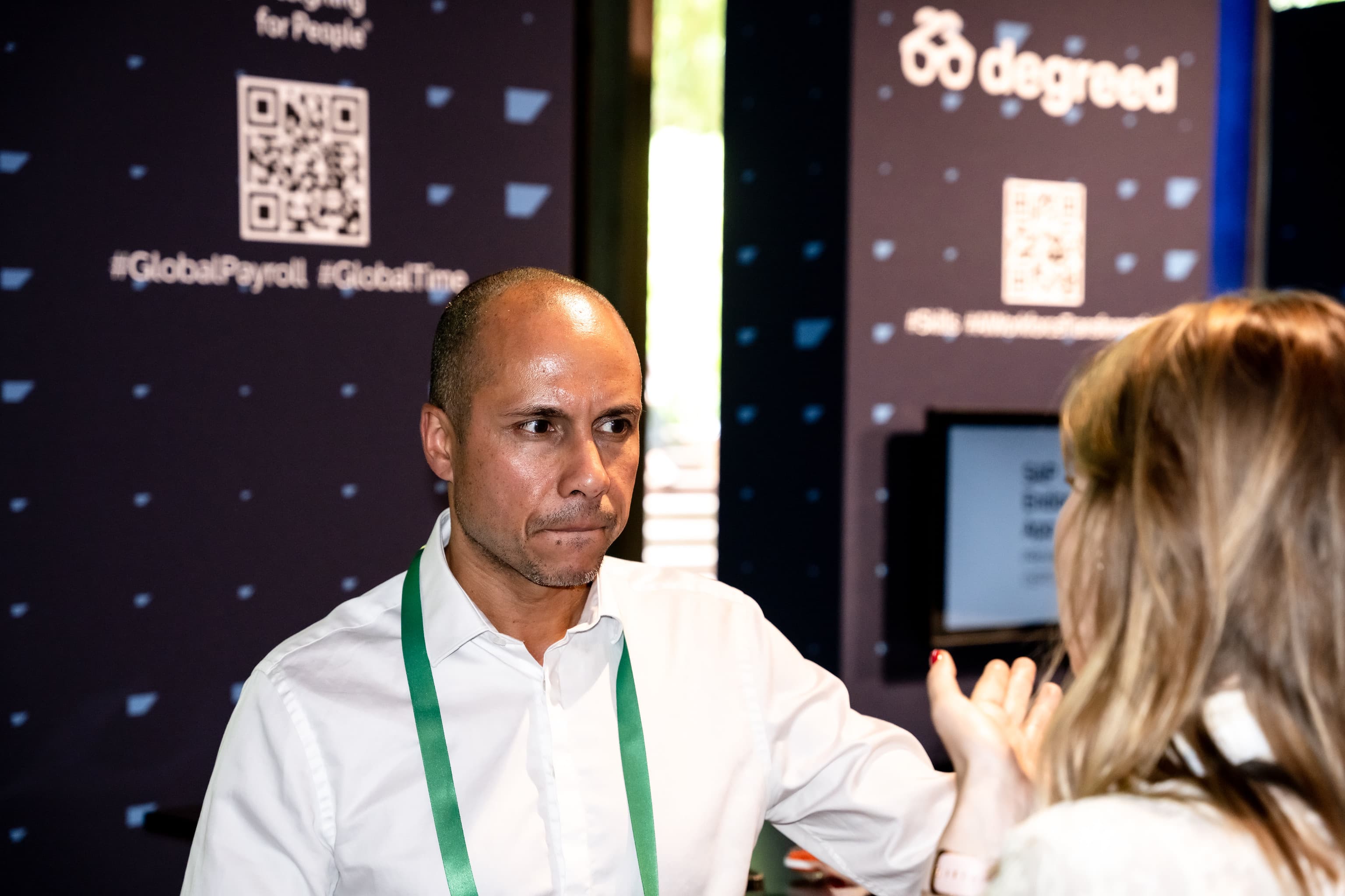 Deux participants en discussion devant un stand partenaire à SAP HR Connect Paris